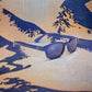 KD's 20122 sunglasses that fit under a motorcycle or ski helmet. For bikers and sportsmen. With a blue metallic frame and blue mirror lenses in front of a decorated canvas.