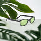 The KD's 2016 sunglasses that fit under a helmet for outdoor activities with light green lenses placed on a white table surrounded by plants.