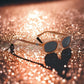 X-KD's 10128 large sunglasses for outdoor activities with a rugged orange metallic frame and gray polycarbonate lenses set against the asphalt.